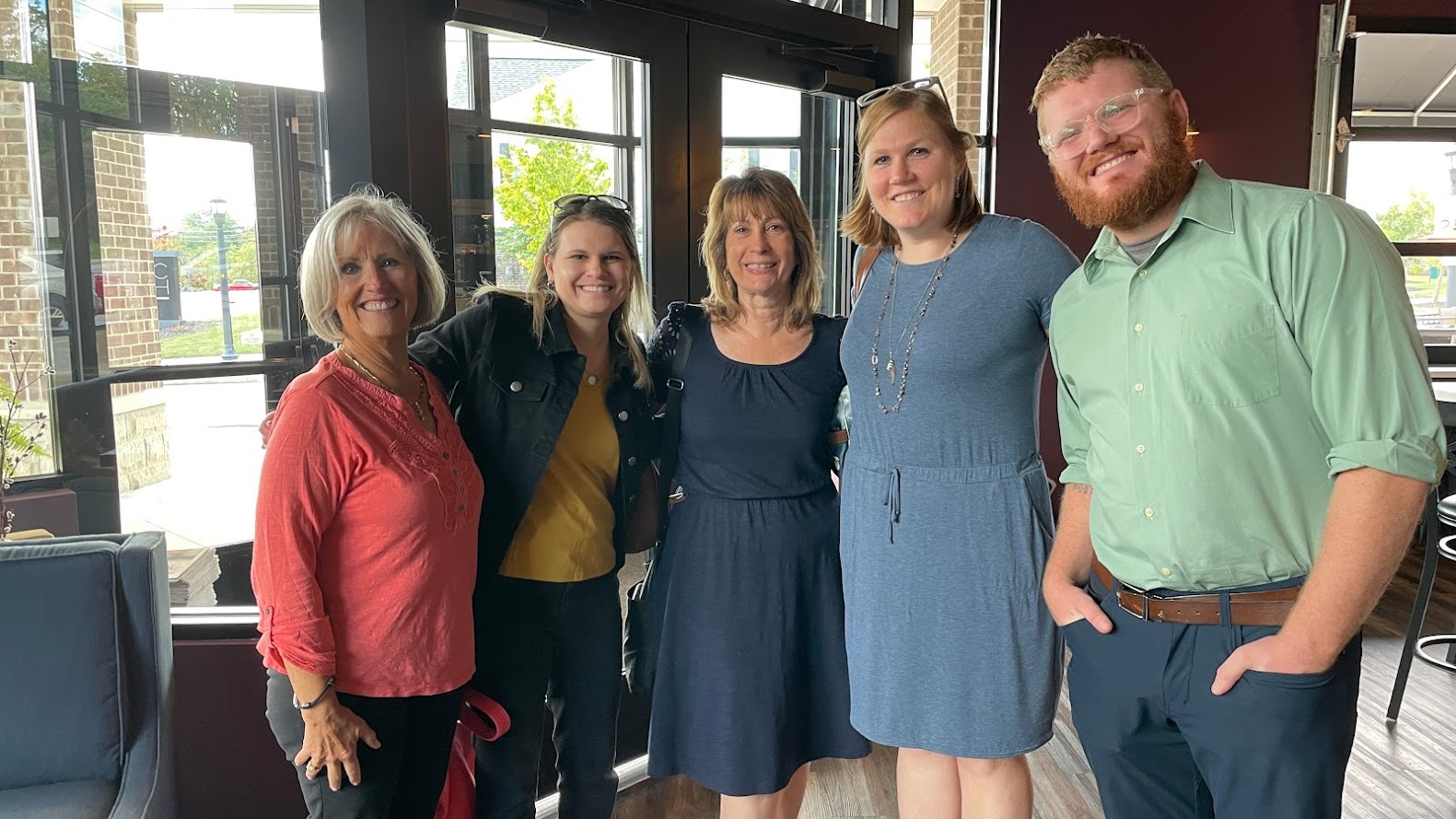 Photo of five people, four women and one man